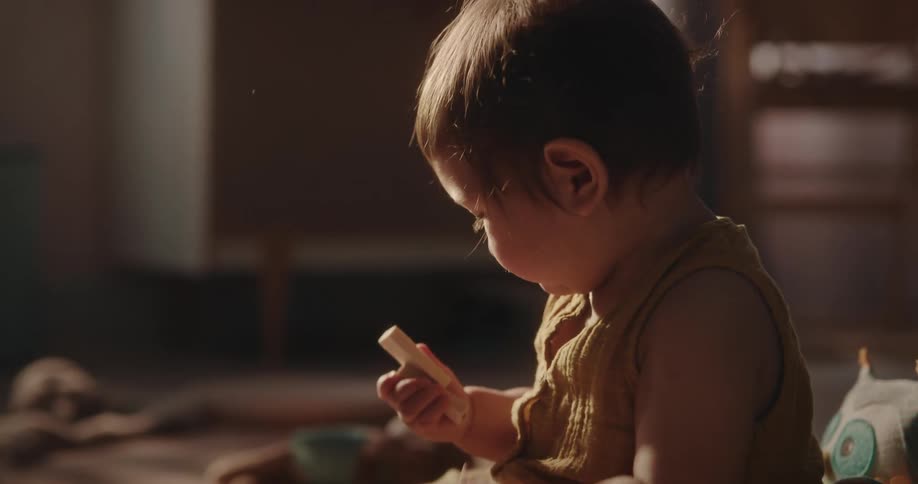 A toddler plays with blocks while sitting on the rug