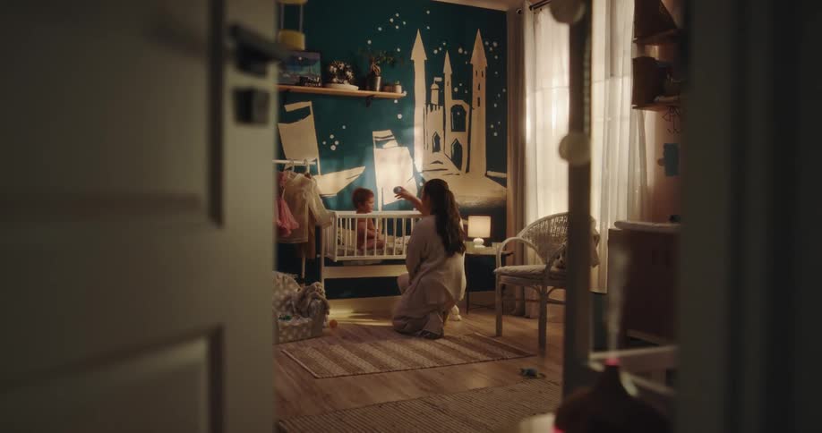 Mother plays with her daughter in the bedroom