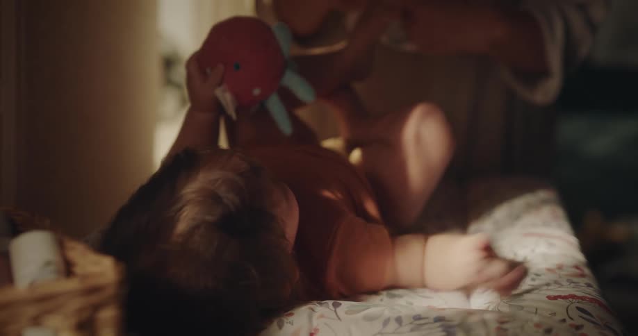 Mother changes toddlers diaper