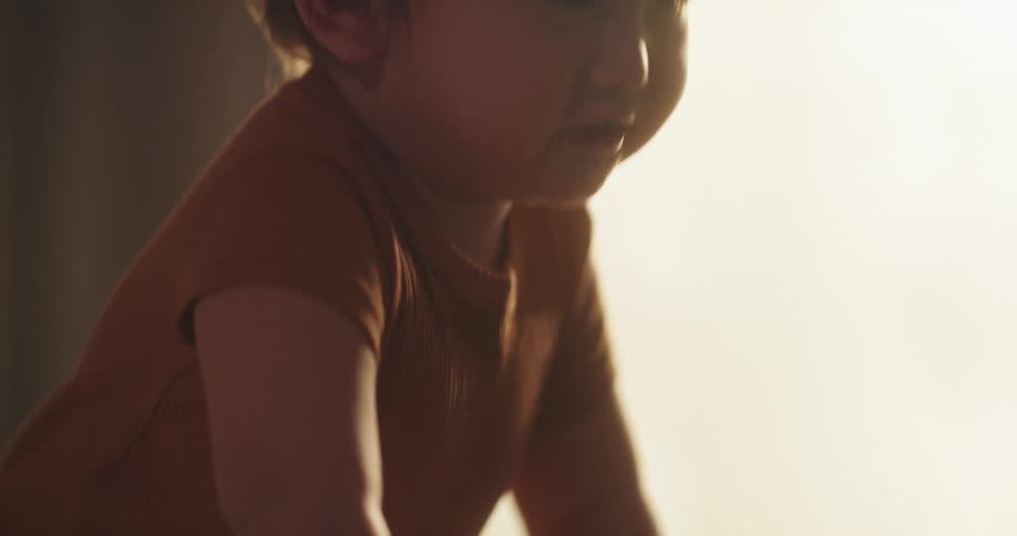Joyful baby standing in a crib reaching out and smiling
