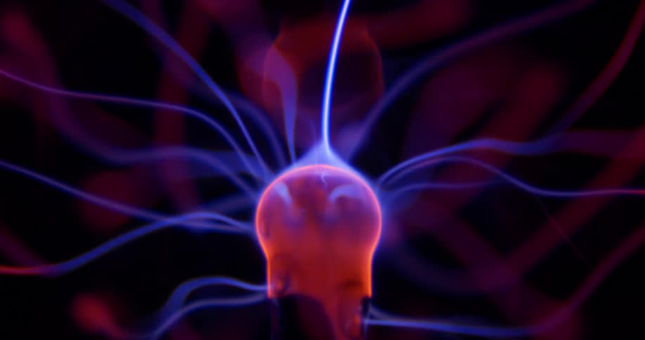 Glowing purple wisps extend and waver into pink illuminated energy from a phosphorescent pink object