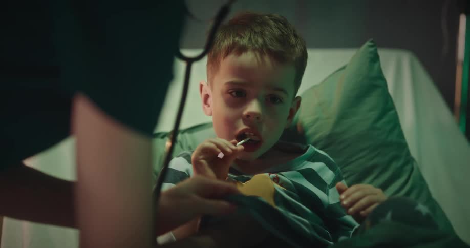 Nurse consulting a child patient who is holding a lollipop