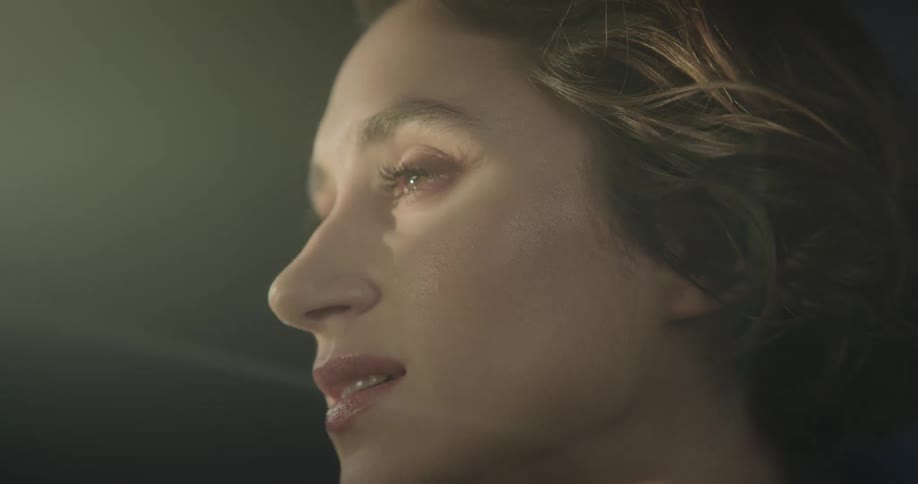 A woman with her face being illuminated and breaks into a smile