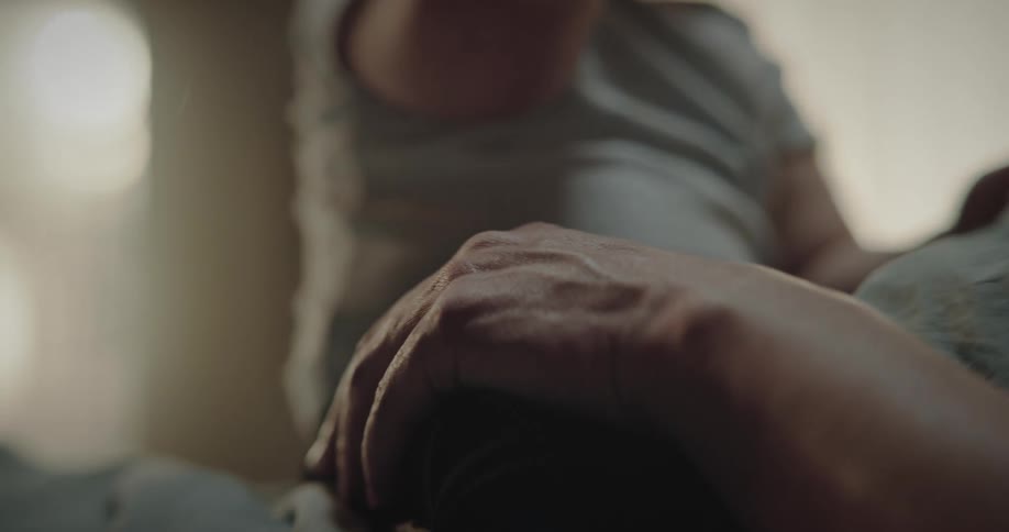 A baby sits on the grandmas stomach while she hold the legs