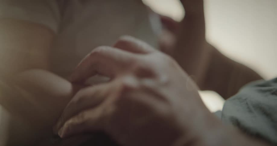 Closeup of the hands of an adult and a baby playing
