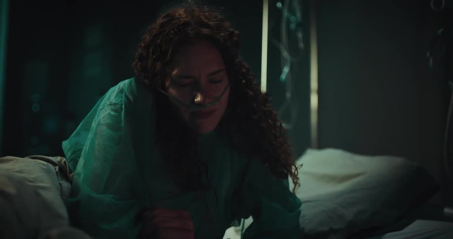 Patient using a cellphone smiling and then laying their head on the pillow