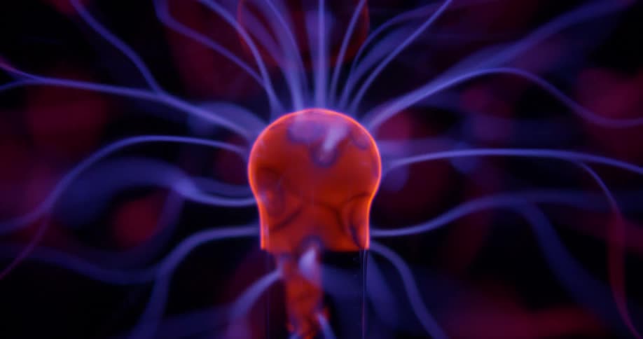 Blue static electricity flows across orange knob in plasma lamp