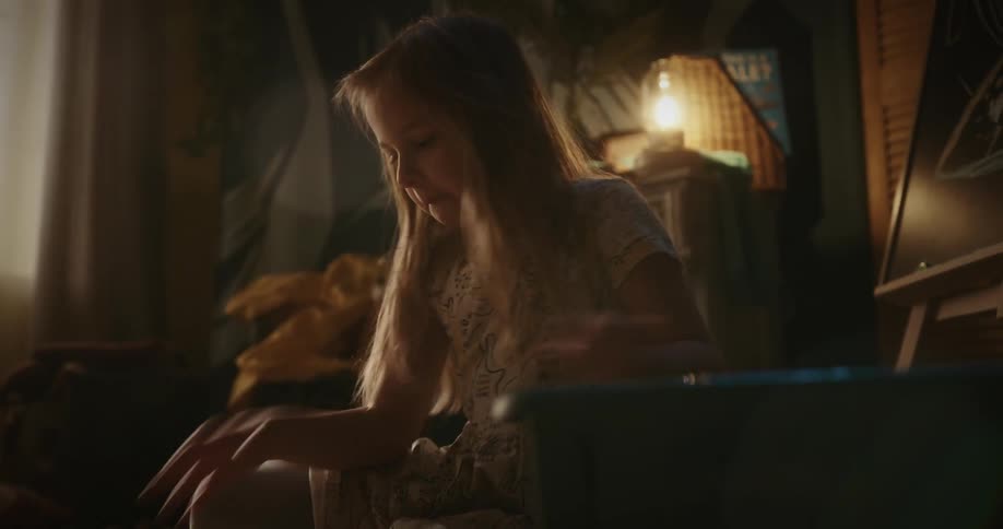 A child is sitting in a room and picking up stuffs