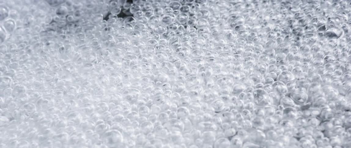 Bubbles rise to the surface and spread across the water