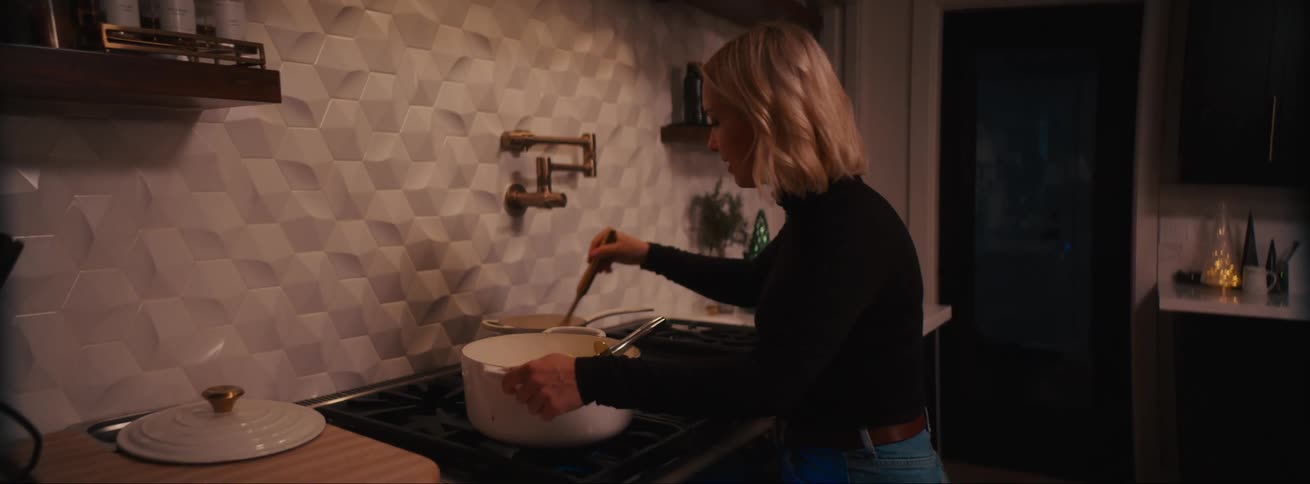 A woman is cooking in the kitchen