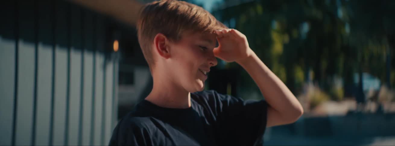 Boy looking up and taking a box handed to him