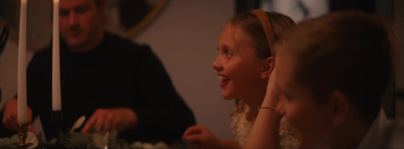 Children and their father sitting at the dinner table happily talking