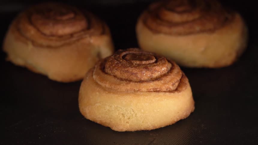 Three cinnamon rolls on dark background