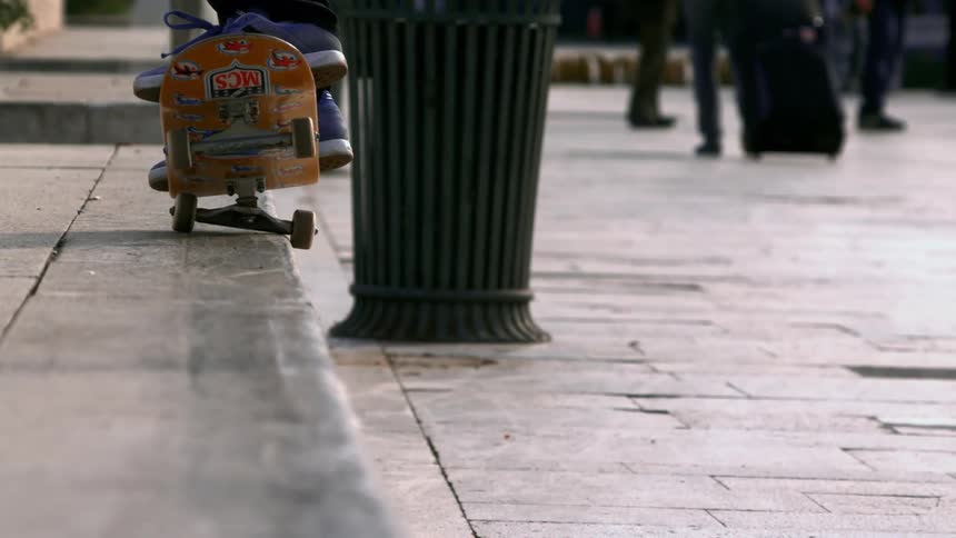 Person performing a skateboard trick sliding on a ramp in the middle of the city and returning to the sidewalk