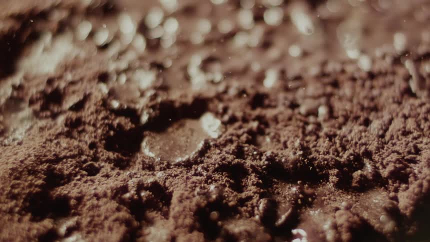 Liquid drops splash onto brown cake mix