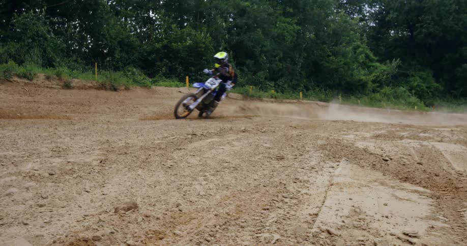 Person riding a motocross bike on a muddy track
