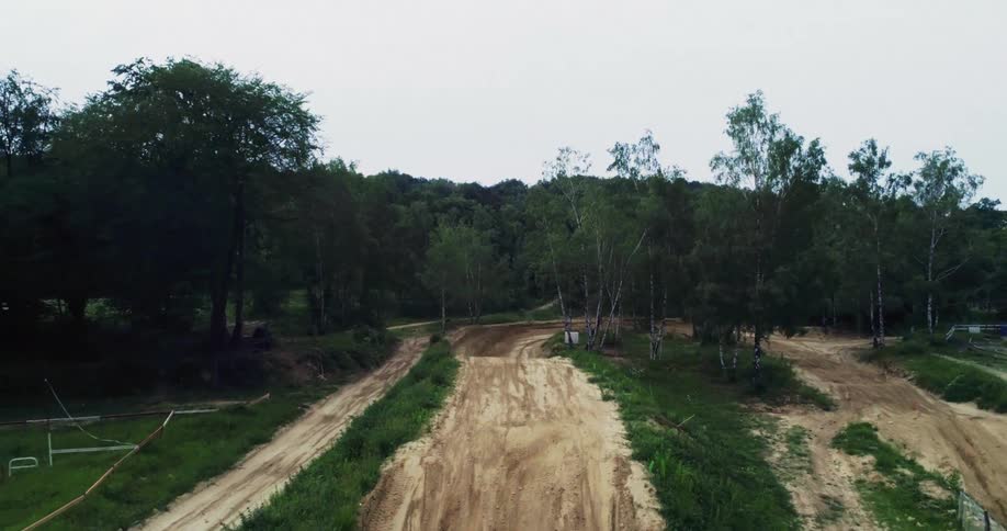 Man performing motocross and jumping a ramp on natural terrain