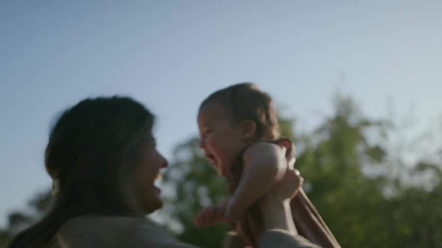 Happy mother and son spinning outdoors