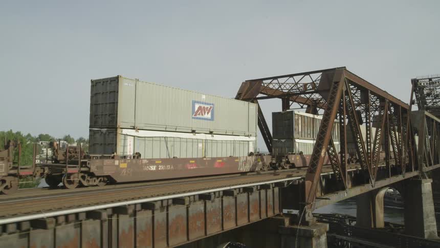 Freight train transporting cargo containers over a bridge