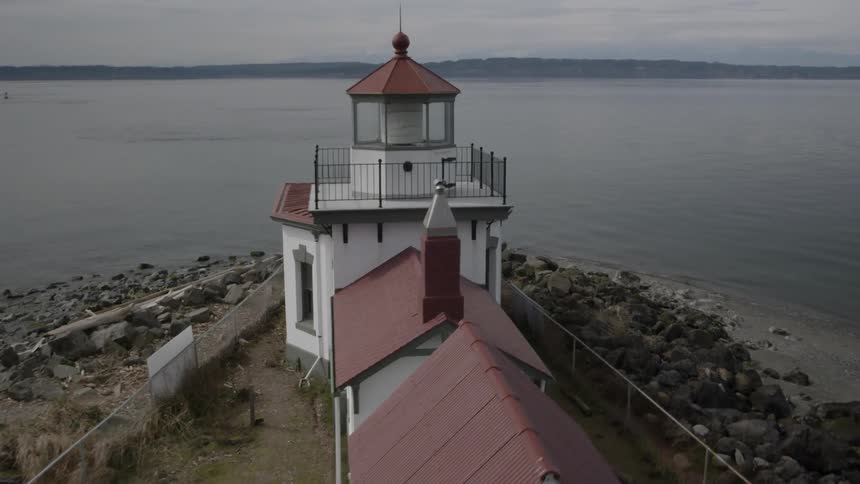 Orbit around a lighthouse surrounded by calm ocean water
