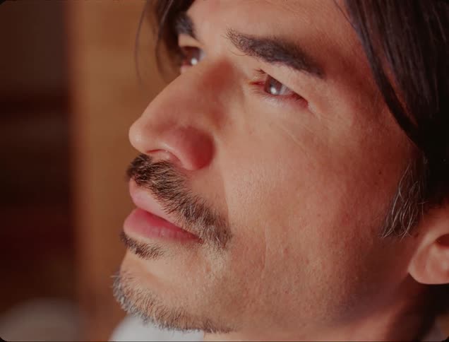A man with a mustache is staring at something