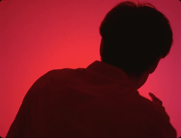Scared man in front of a wall of bright red light