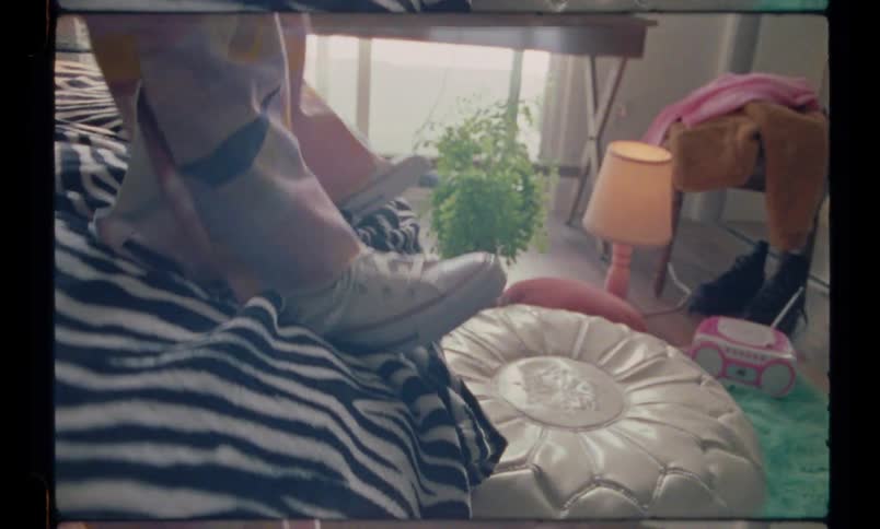 A person is lying on a bed and puts on pants and takes them off