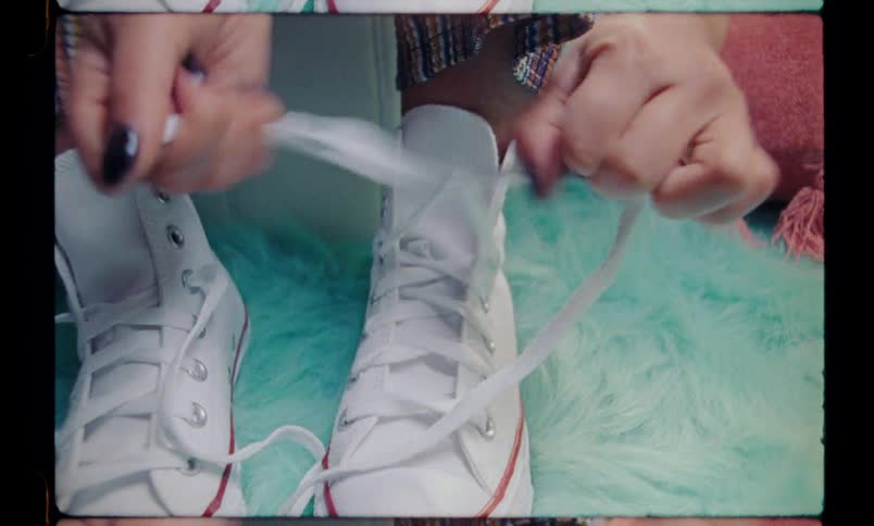 Hands of a person tying the shoelaces of their shoes