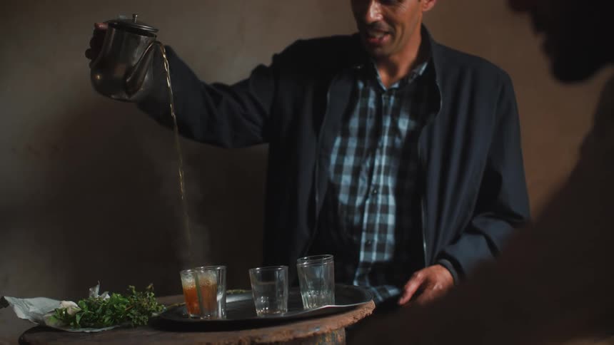 Man pouring hot tea into a cup