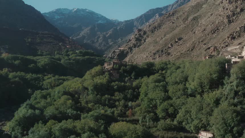 Aerial of large buildings surrounded by trees in valley
