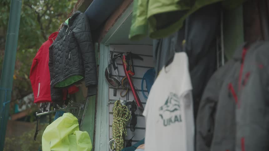 Man enters a small rural mountaineering shop