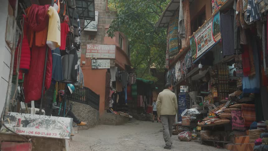 People walk down street near retail vendor stalls