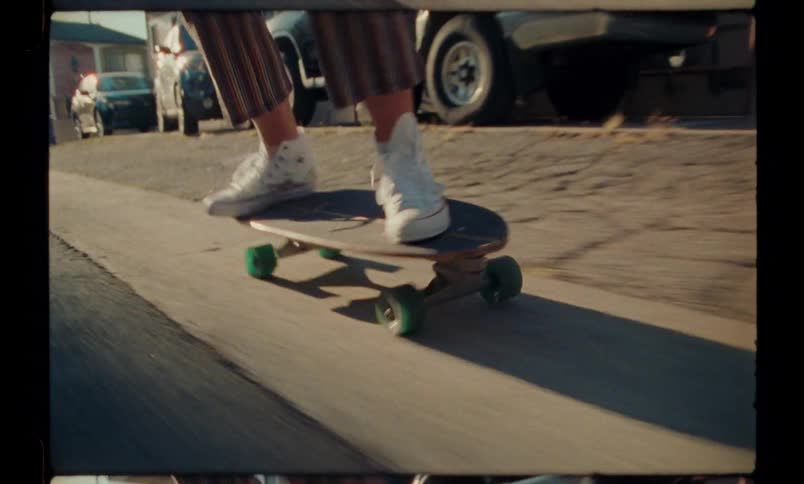 Legs of a person on a skateboard losing balance on the sidewalk of the street