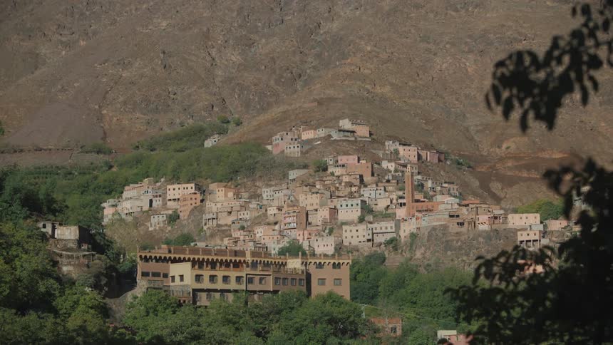 Landscape of buildings built on rocks with nearby trees on a sunny day