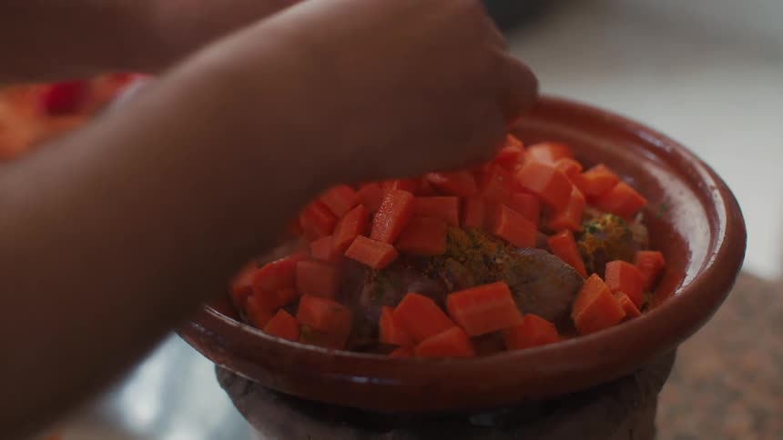 Hands of a woman preparing a dish with proteins and carrots
