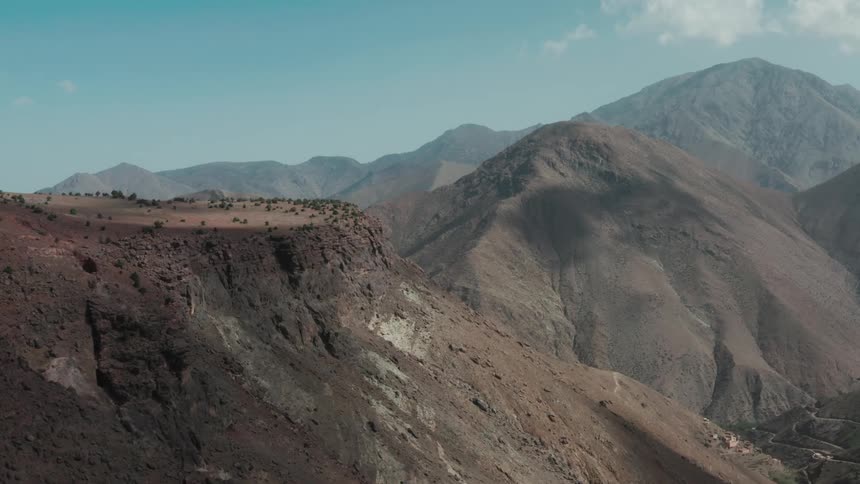 Panoramic aerial view of peaks and mountains on a day with a blue sky