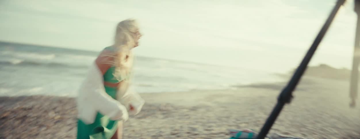 Woman frolicking on the beach sand with extreme happiness