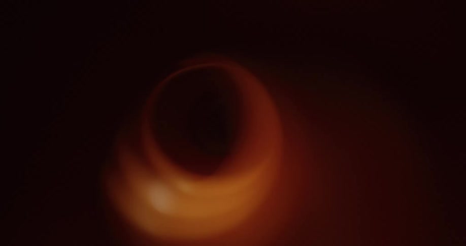 A tunnel with a dark hole at the end being illuminated by a passing light