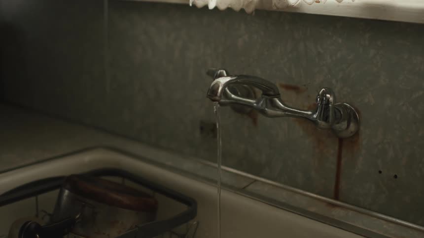 View inside a house with the kitchen sink faucet running