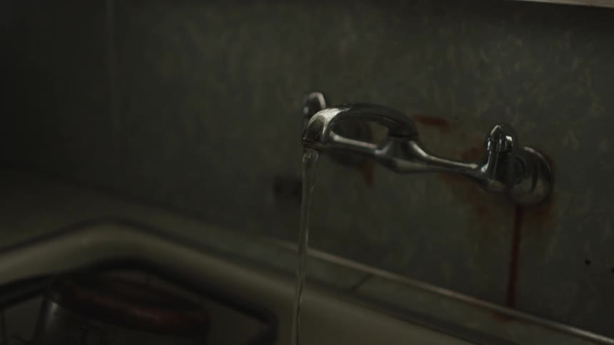 Water coming out of a metal faucet in the kitchen