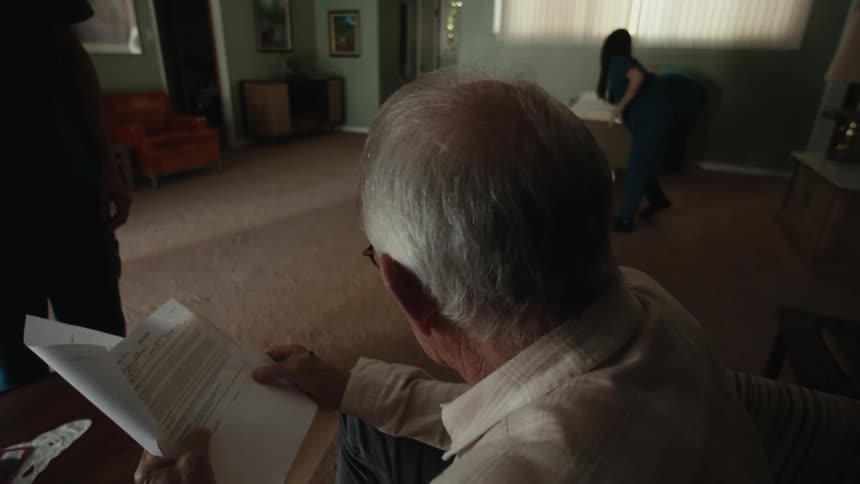 A sad man signing medical documents
