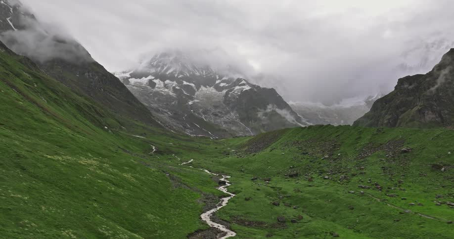 A green valley under snowy mountain peaks