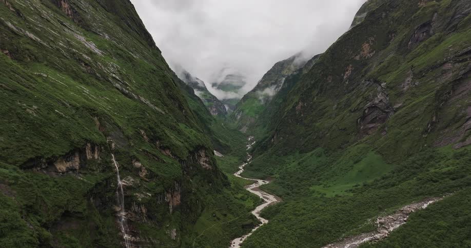 River flowing amidst mountains at cloud level