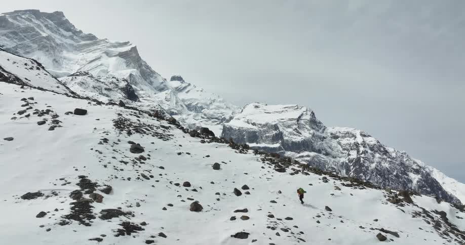A person walking up a snowcovered mountain