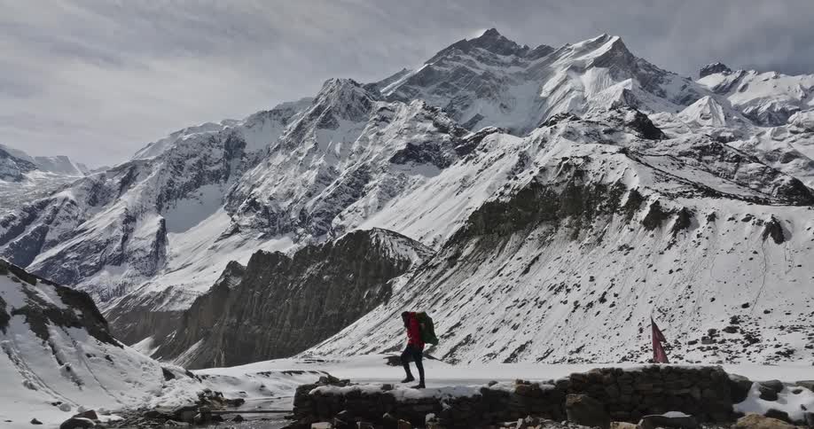 A person is hiking past the mountains