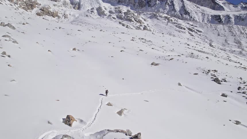 A hiker crossing a snowy valley