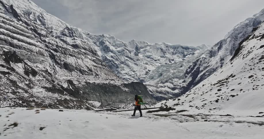 A person hiking in the mountains covered all in snow in the winter