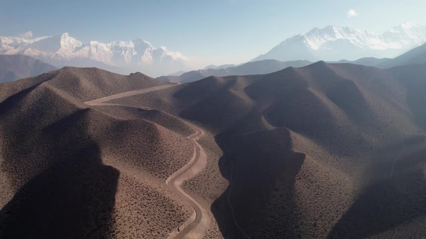 Aerial panorama of desert dunes with a background of a snowcovered mountain range