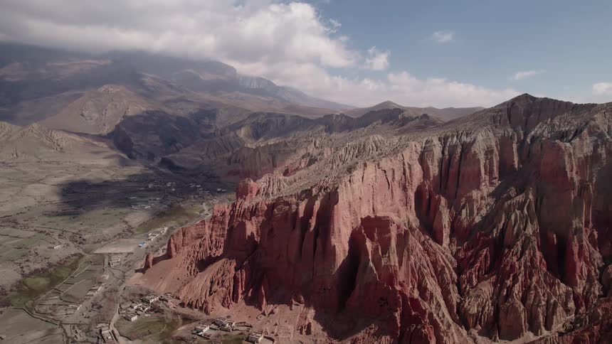 A rural region with a large mountain with several cuts in it