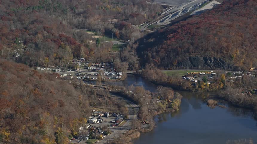 Aerial panorama of a central lake with a highway around it with parked and moving vehicles